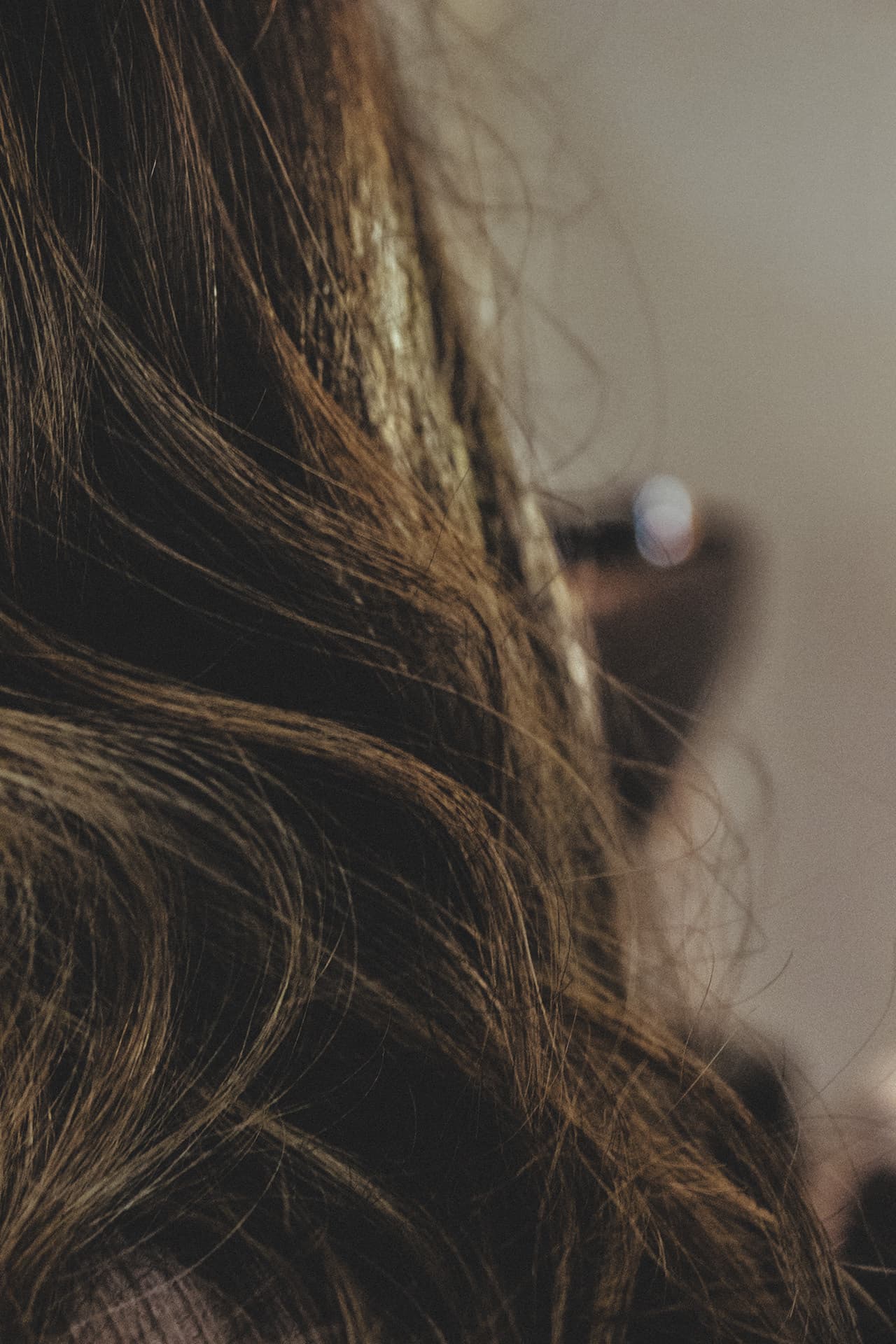 Close-up of soft brunette curls with golden dimension