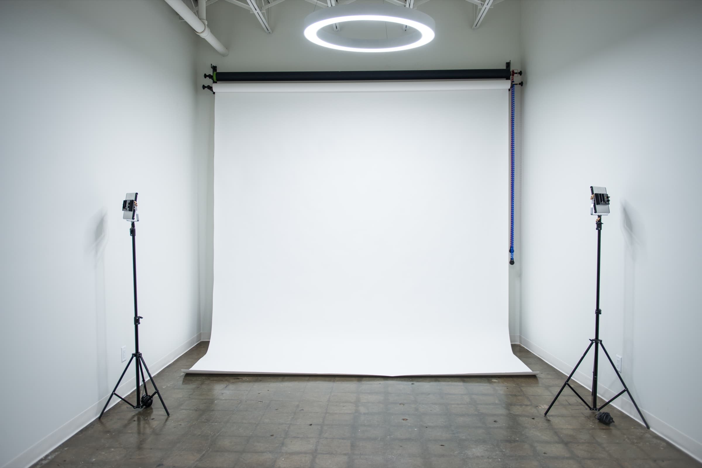 White seamless photoshoot studio with a ring light and two light stands at House of Snob in Edmonton