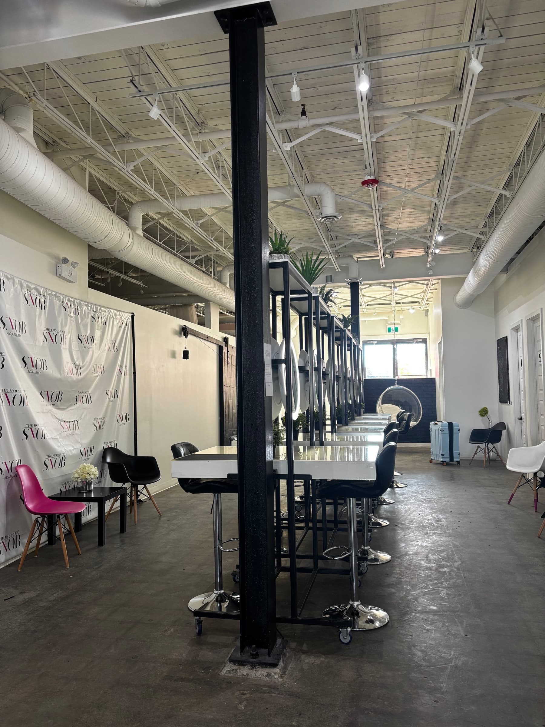 The open studio at House of Snob in Edmonton, with a SNOB step-and-repeat backdrop and a row of styling stations